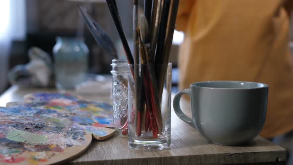 Aristic Tools and Cup of Hot Drink on Work Table