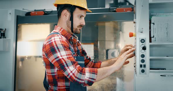 Industry Worker Entering Data in CNC Machine at Factory