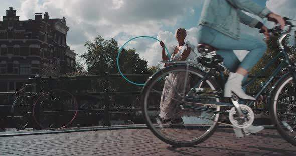 Woman spins Hula Hoop as bikes pass by