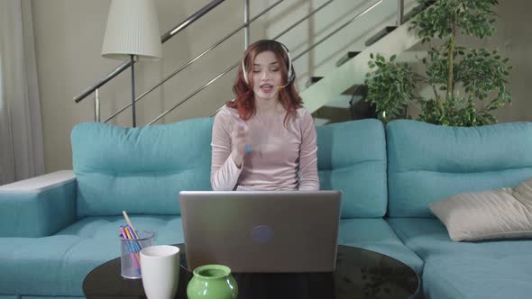 Focused Woman Distance Teacher Online Tutor Wear Headphone Conferencing On Laptop