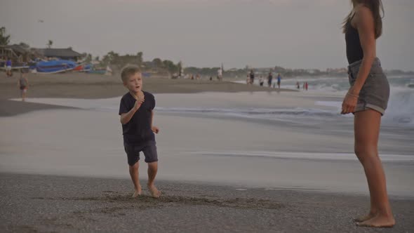 Mother and Son Dancing on Beach at Sunset