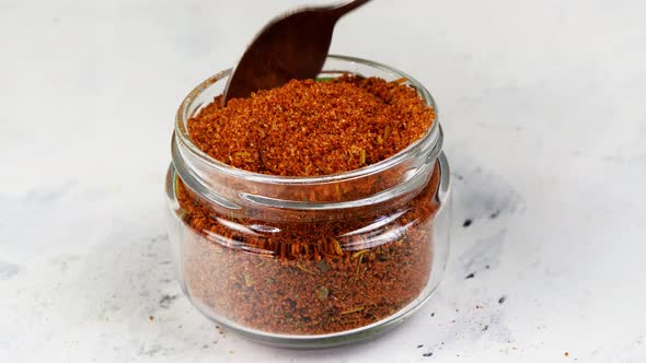 Chef Taking with Teaspoon Spices Ground Red Pepper or Chili From Glass Spice Jar