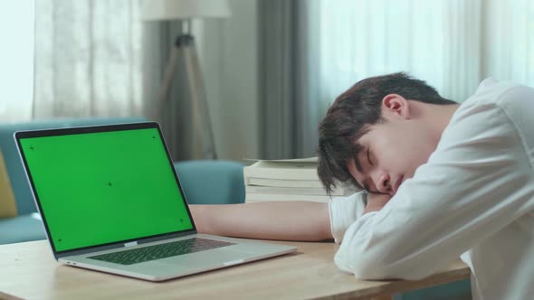 Asian Man Student Sleeping While Using Green Screen Computer At Home