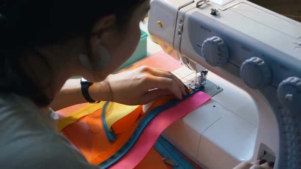 Seamstress Sews Fabric Strips with Sewing Machine Closeup