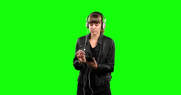 Front view of Caucasian woman listening music with green screen