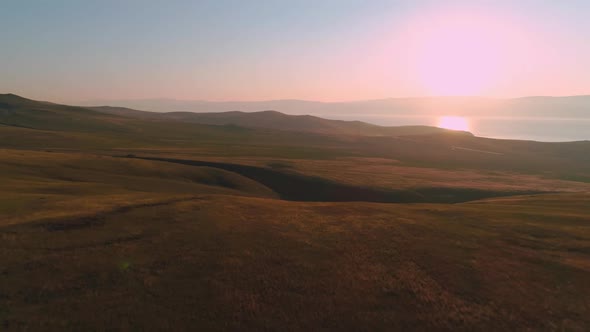 Aerial Field of Dry Yellow Grass. Steppe on Olkhon Island. Lake Baikal, Russia. Drone Footage Hills