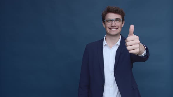 Male Model in Business Suit and Glasses Giving a Thumbs Up