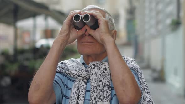 Senior Man Tourist Exploring Town. Looking in Binoculars. Travel Lviv, Ukraine