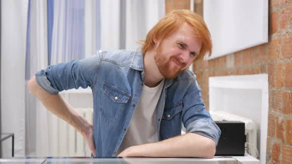 Beard Man with Back Pain Trying to Relax at Work