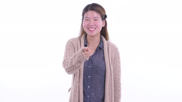 Happy Young Asian Woman Pointing at Camera Ready for Winter