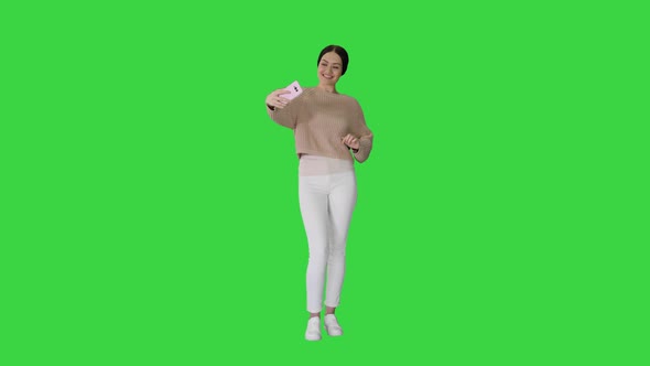 Pretty Brunette Taking a Selfie on a Green Screen, Chroma Key.