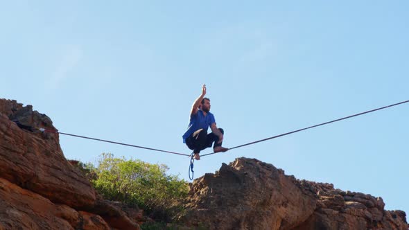 Highline athlete walking on slackline in mountains