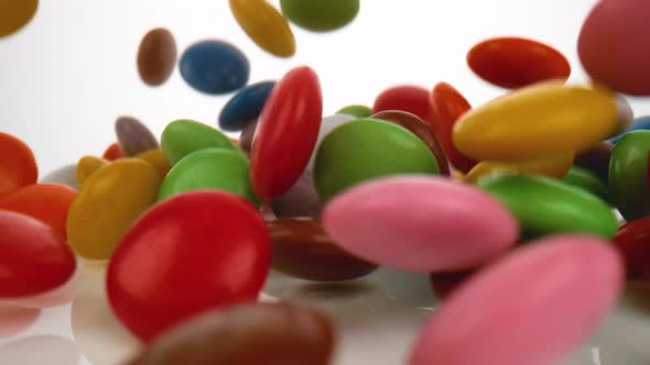 Camera follows m&m’s falling on surface. Slow Motion.