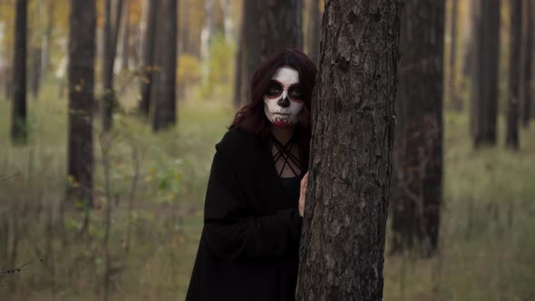 Witch with Santa Muerte Makeup is Hiding Behind Tree and Appears Again