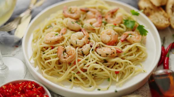 Spaghetti with Shrimps on White Ceramic Plate and Served with Glass of White Wine