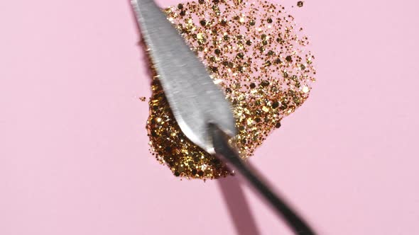 Brushstrokes of Gold Paint Brush Applied Isolated on a Pink Background