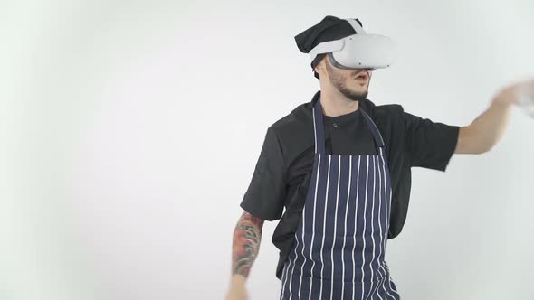 Chef Wearing Virtual Reality Headset Playing Game with Swords, Slashing Around Using Controllers