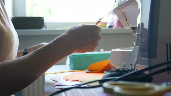 Seamstress Hands Hold Fabric and Cut Thread with Scissors