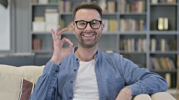 Portrait of Cheerful Young Man Doing OK Sign in Loft Office 