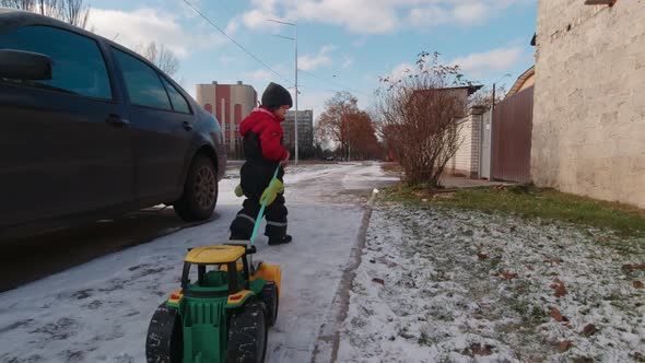 A Boy With A Toy Car Walks Outdoors