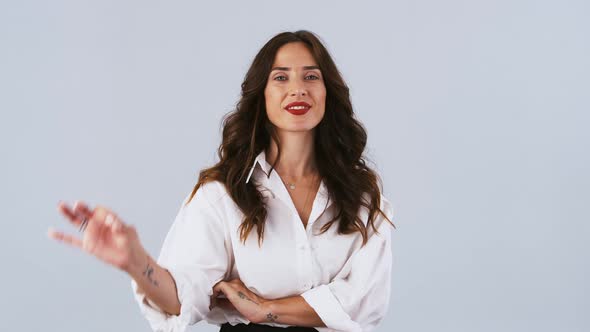 Brunette Female in White Shirt is Looking Happy Smiling and Showing Okay Sign While Posing Against