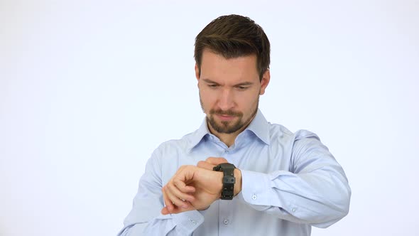 A Young Handsome Man Works on a Touchscreen Wristwatch, Then Smiles at the Camera - White Screen