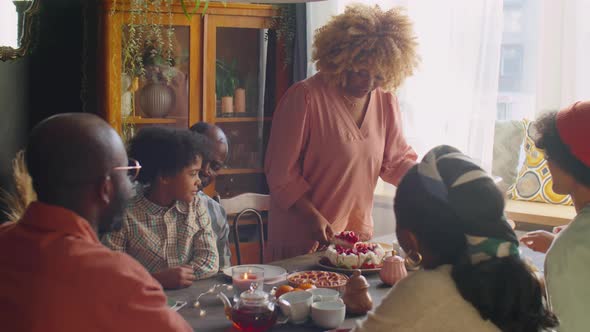 Woman Serving Sweet Cake for Family at Home Dinner