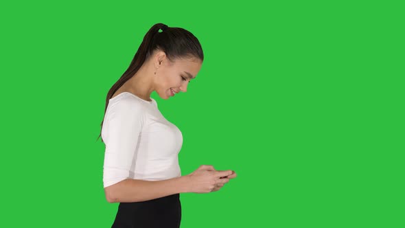 Business Woman Using Smartphone and Walking on a Green Screen, Chroma Key