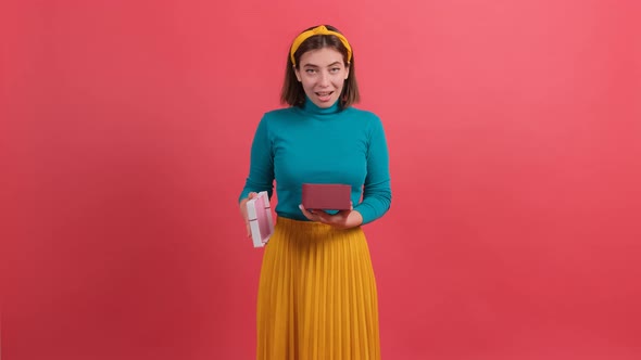 Portrait of Happy Woman Opening Gift Box Over Red Background