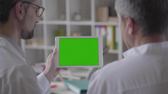 Two Experienced Male Doctors Checking Information on the Tablet