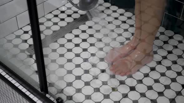 Woman Stands in Shower with Black and White Tiles