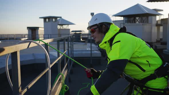 Industrial Climber Removes Rope From Building After Work