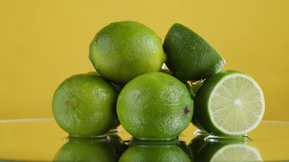 Green Limes Isolated on Yellow Background Fresh and Ripe Citrus Fruits