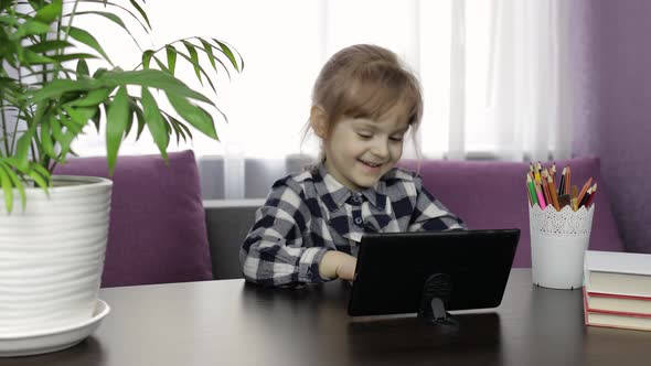 Girl Doing Lessons at Home Using Digital Tablet Computer. Distance Education