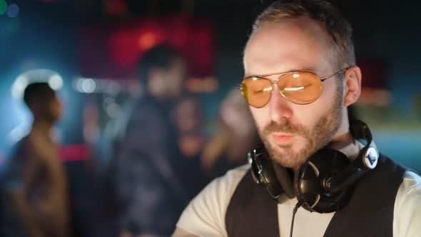 DJ is Playing Music at a Party in a Nightclub