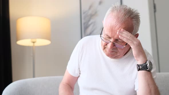 Portrait of Upset Senior Man Massaging Temples Touching Aching Head Experiencing Severe Headache