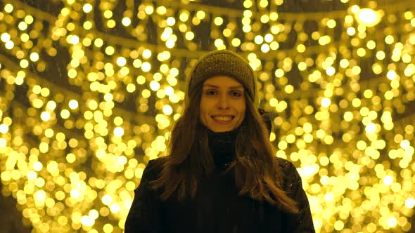 Portrait of a Happy Girl on a Evening Street Decorated with Christmas Lights