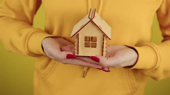 Body Part of Woman with Small Wooden House in Hands