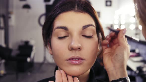 Unrecognizable Make Up Artist's Hand Applies Eyeliner in the Eyes' Outer V Section of a Beautiful