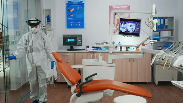 Nurse with Protection Suit Inviting Next Patient in Stomatology Room