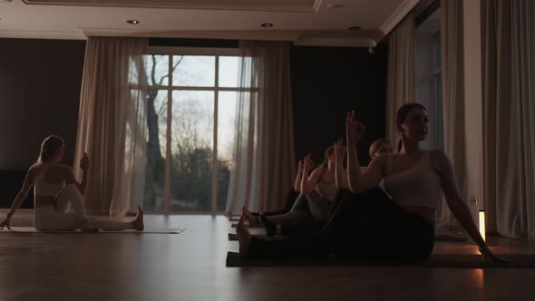 A Group of Women is Engaged in Stretching and Balance with an Instructor in a Beautiful Hall with