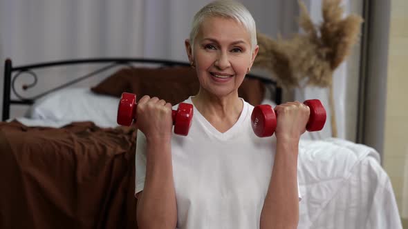 Closeup of Senior Woman with Lifting Dumbbells at Home