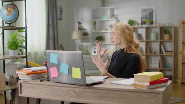 Young Woman Communicating By Video Call at Home in the Living Room at the Desk