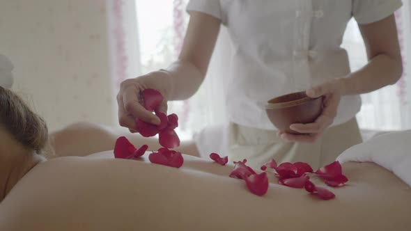 Young woman having hot stone massage in spa, relax and aromatherapy