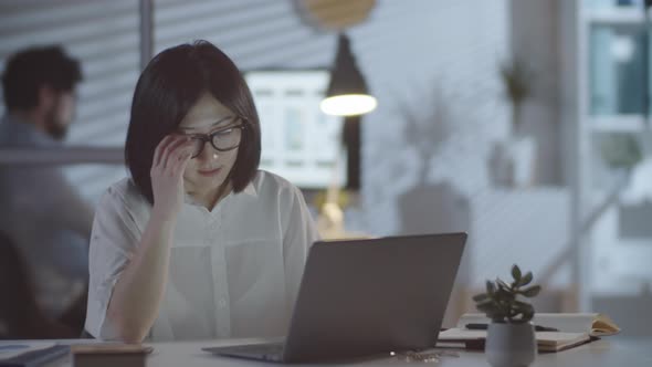 Tired Asian Businesswoman Working Overtime