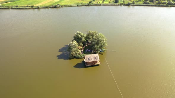 Small island with green trees and a house in the river.