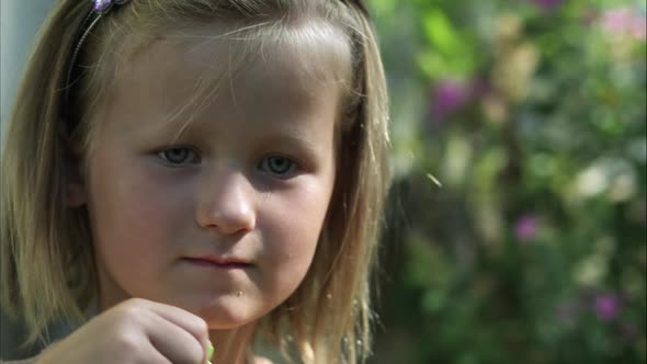 Slow close-up handheld shot of a caucasian girl blowing bubbles