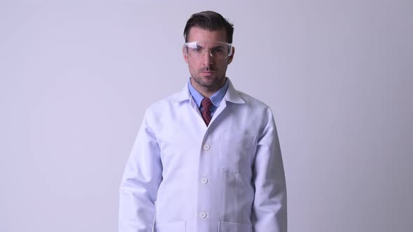 Young Hispanic Man Doctor Removing Protective Glasses