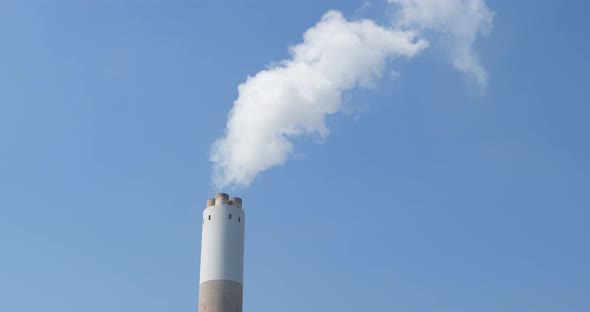 Air pollution by smoke coming out of the factory chimney