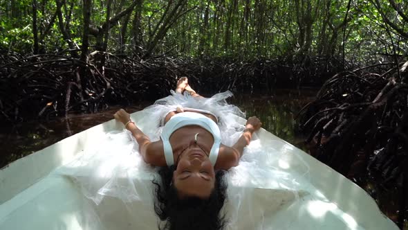 Beautiful Woman is Lying on the Boat in the Mangroves Forest River